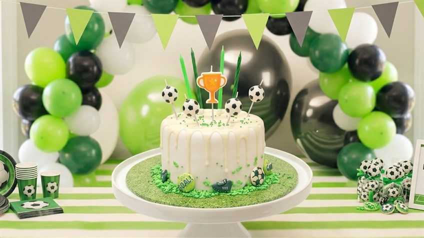 Football cake with white drip icing and football candles.